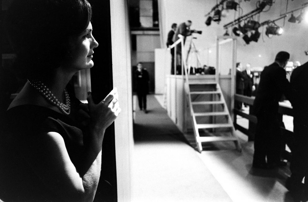 Jackie Kennedy watches from the wings as her husband debates Richard Nixon, 1960.