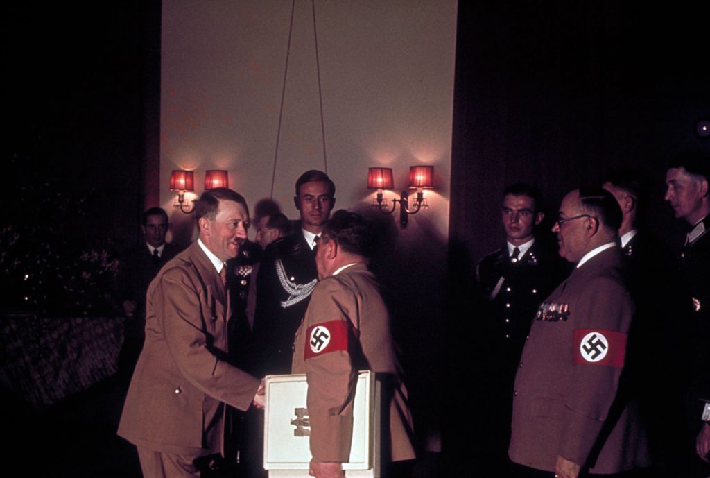 Adolf Hitler shakes hands with one of his personal photographers, Heinrich Hoffmann, while his doctor, Theodor Morrell (right) waits to greet the Fuhrer on Hitler's 50th birthday, April 20, 1939, in Berlin.