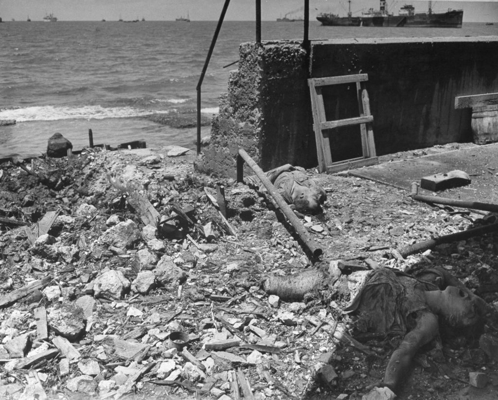 After an Arab air raid, bodies of dead Jews lie in the rubble along the Tel Aviv waterfront.